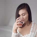 A woman drinking water before bedtime