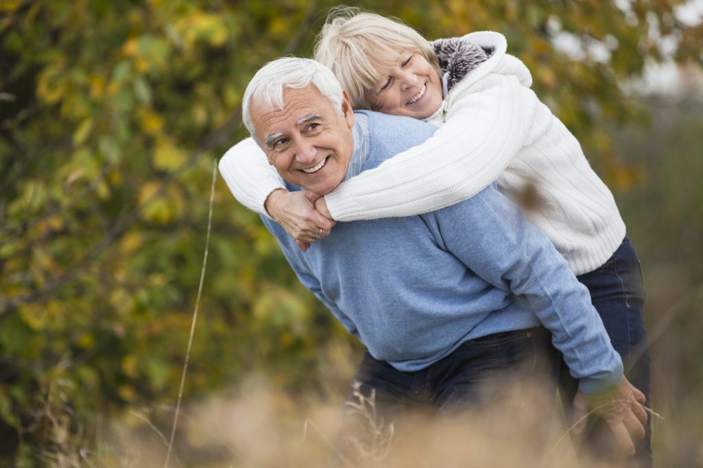 Smiling senior giving his wife a piggyback